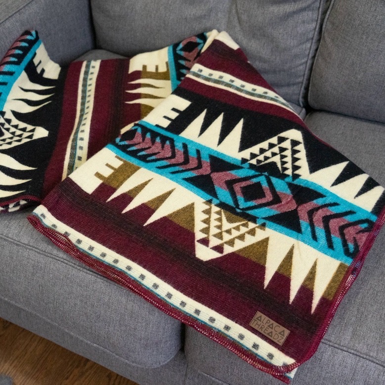 Alpakkapledd Andisk SouthWest - brettet på sofa