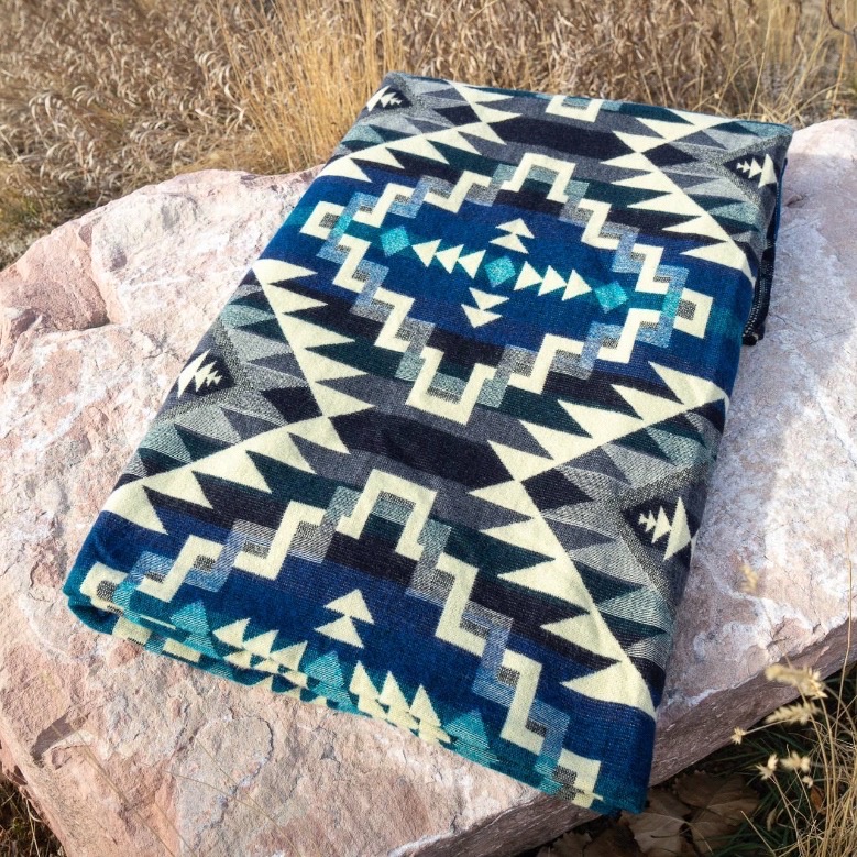 Alpakkapledd Andisk Blue Chakana brettet på stein